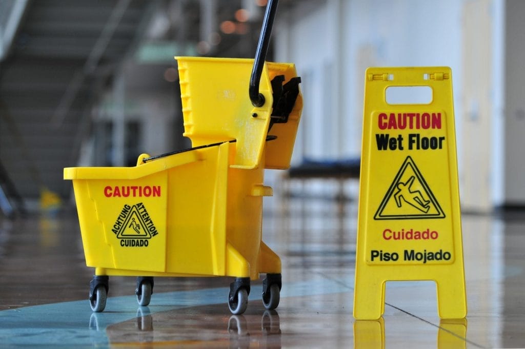 kelowna janitorial services yellow safety sign, mop and bucket on floor