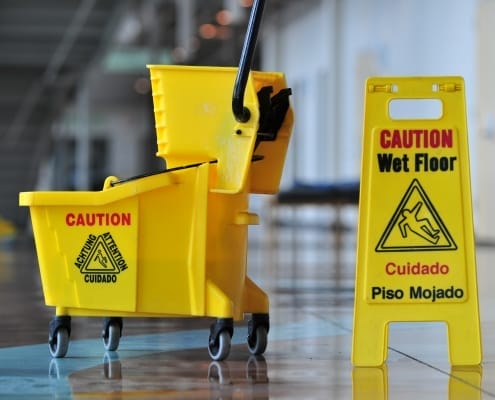 kelowna janitorial services yellow safety sign, mop and bucket on floor