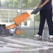 Kamloops office cleaning services - partial body of person using an orange floor polishing machine