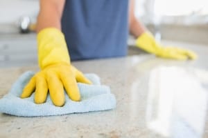 Expert Kelowna janitorial services - Woman cleaning the counter in the kitchen