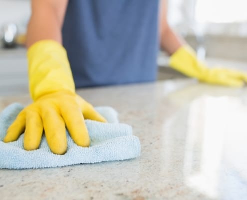 Expert Kelowna janitorial services - Woman cleaning the counter in the kitchen